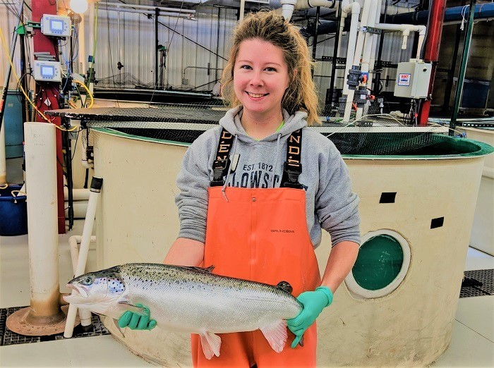 Marissa McIntyre holds up Atlantic salmon at UWSP NADF