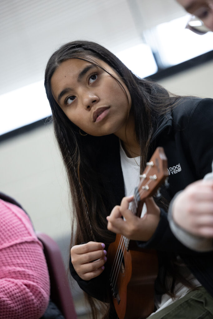 student holding guitar in classroom