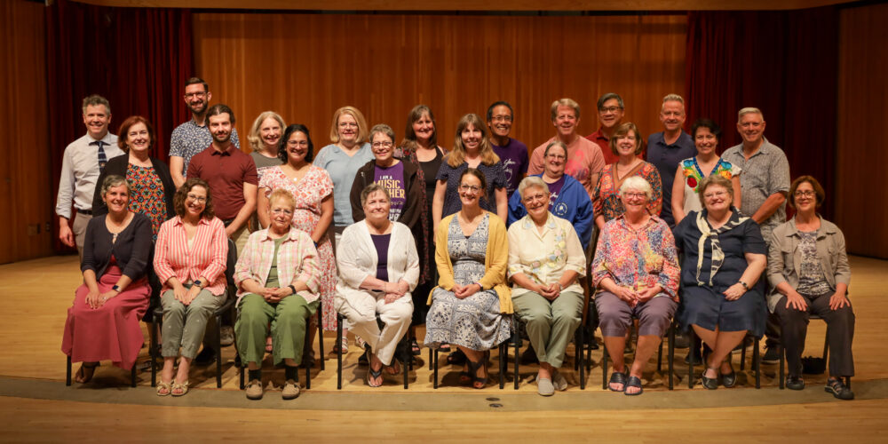 American Suzuki Institute faculty group poses together onstage for annual photo.