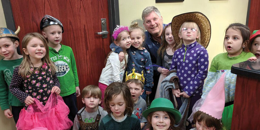 Faculty with group of preschool students wearing fantasy costumes.