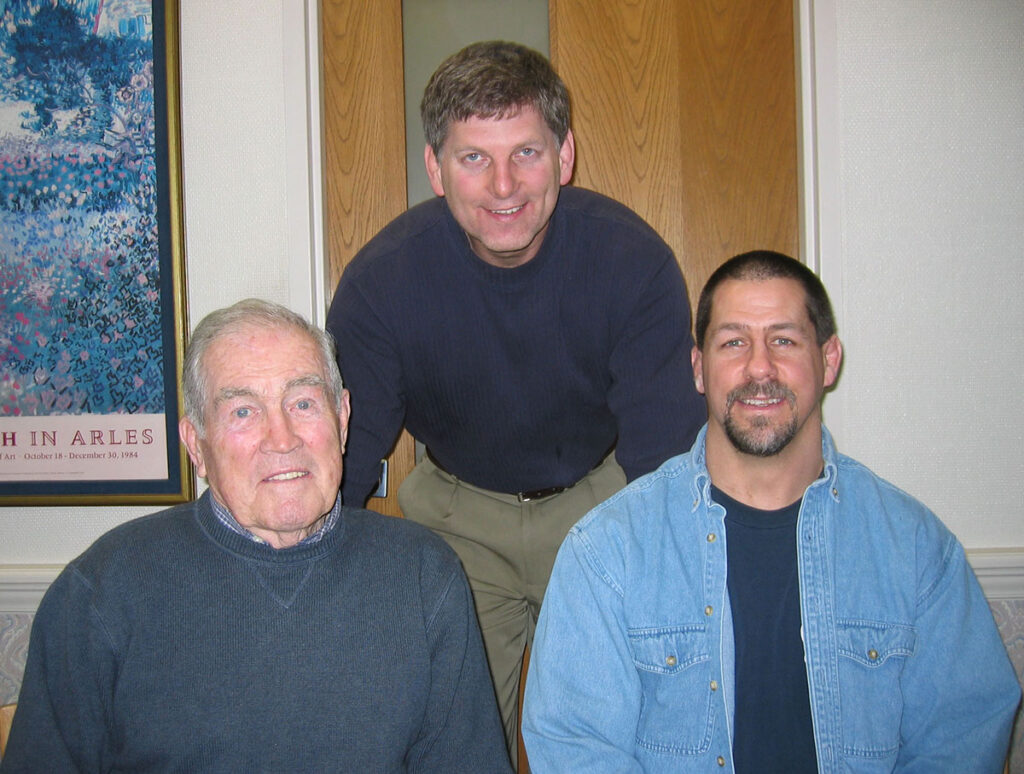 Three men posing for a photo indoors.