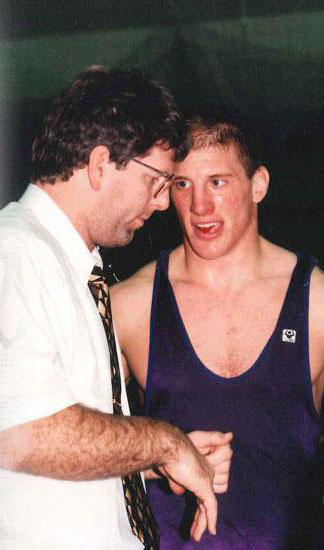 Coach giving a wrestler instructions during a match.