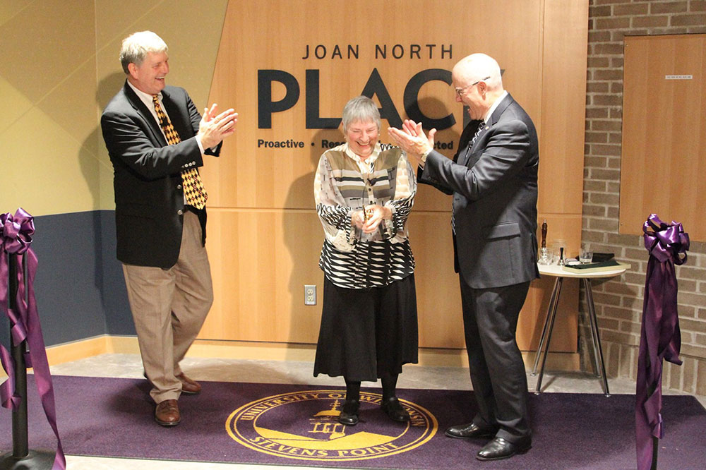 Recognition moment at Joan North Place as attendees applaud.