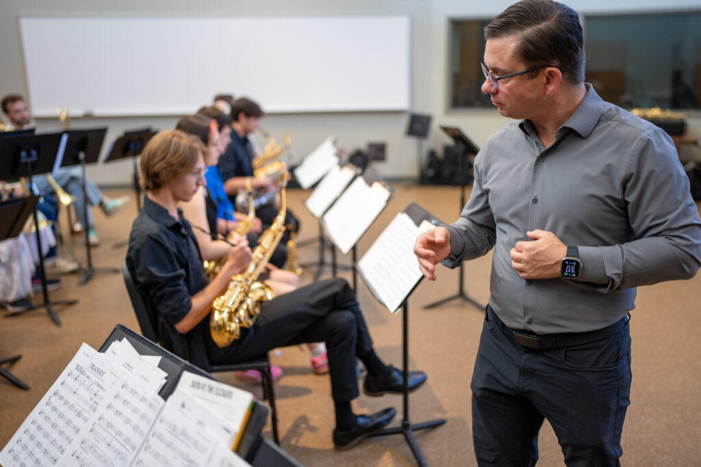 Musical instructor looking at student in classroom.