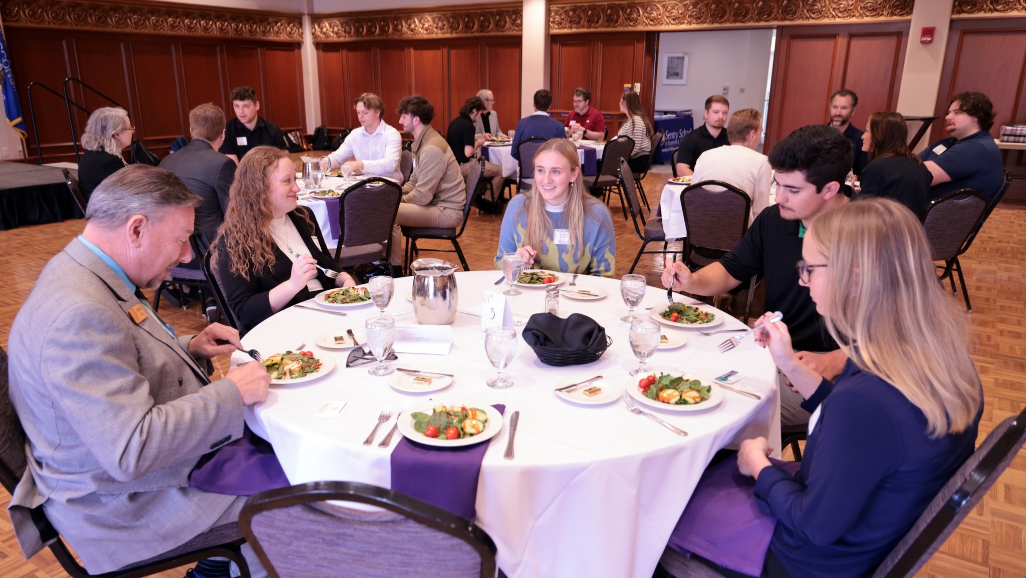 Gracie with a table of people at a business etiquette dinner