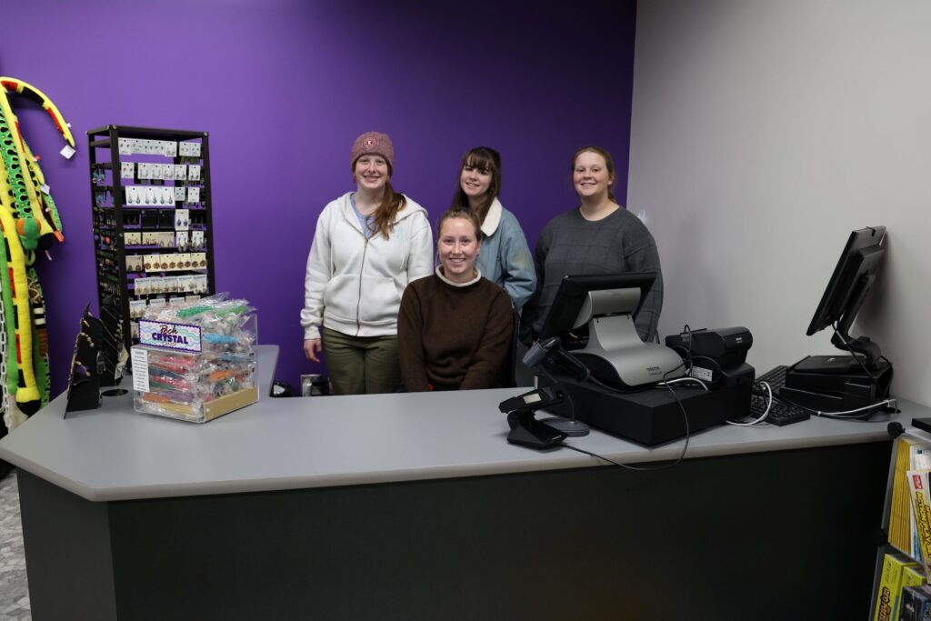 students in group at museum gift shop desk smiling