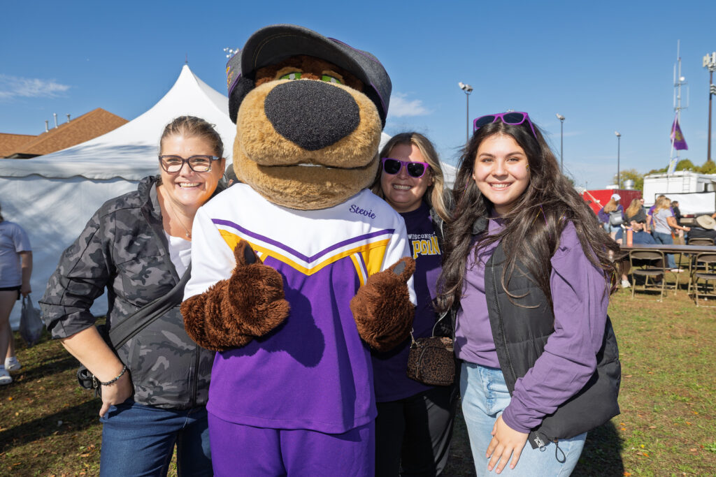 Three students at UWSP Homecoming with Stevie Pointer the mascot