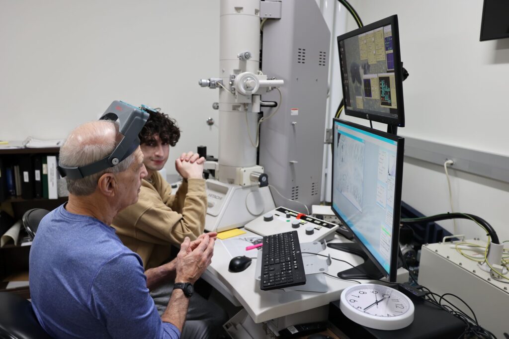 Student works with faculty member to study an image under the TEM, transmission electron microscope