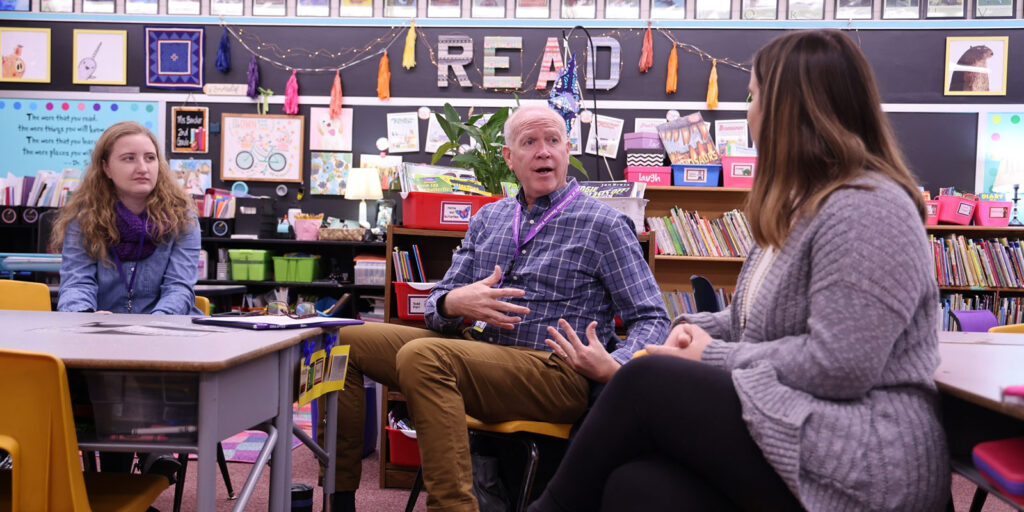 A participant reads from a children’s book while others listen during a literacy workshop.