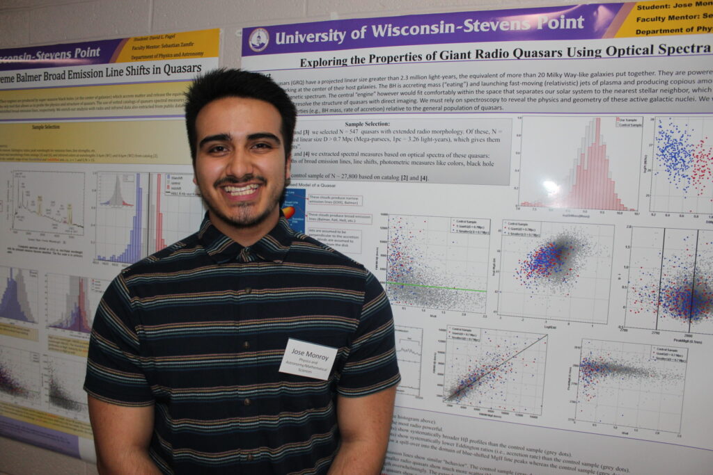 Student poses in front of quasar research poster in 2025 event.