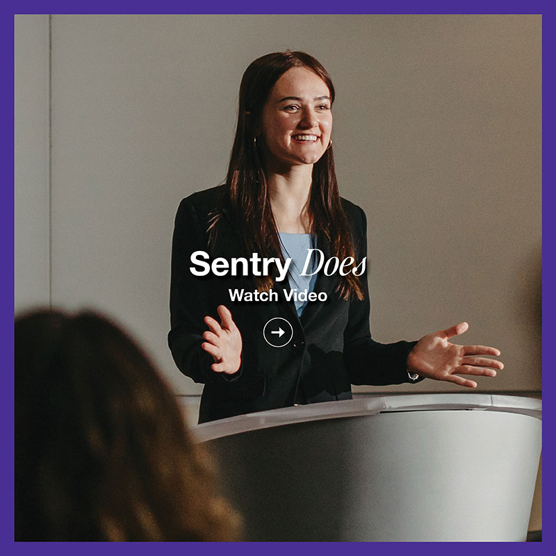 Student presenter speaking at a podium during a classroom presentation
