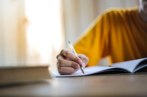 hand holds pen on paper