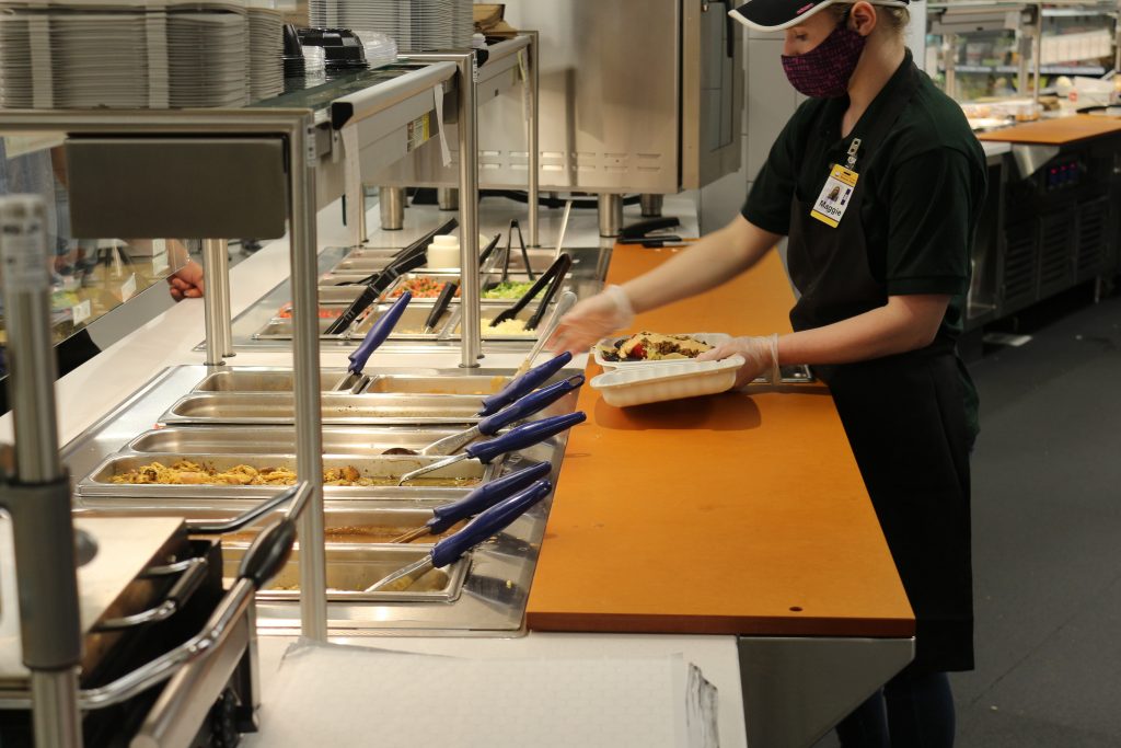 UWSP dining student employee at making nachos at Lower Marketplace