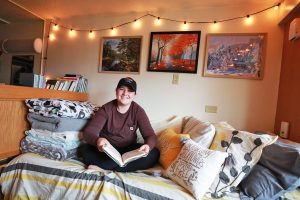 UWSP student sitting in their dorm room reading a book