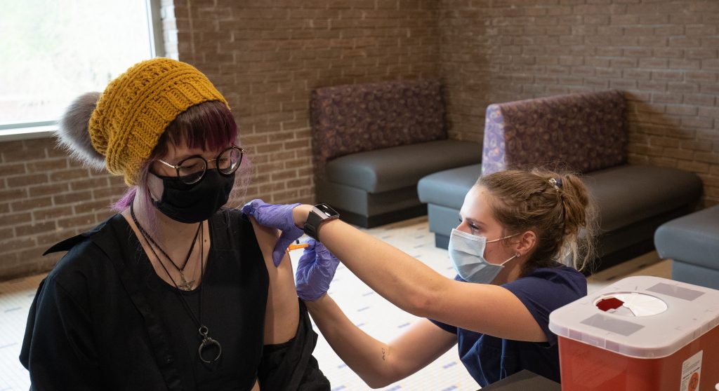 A female student receiving their COVID-19 vaccine on campus.