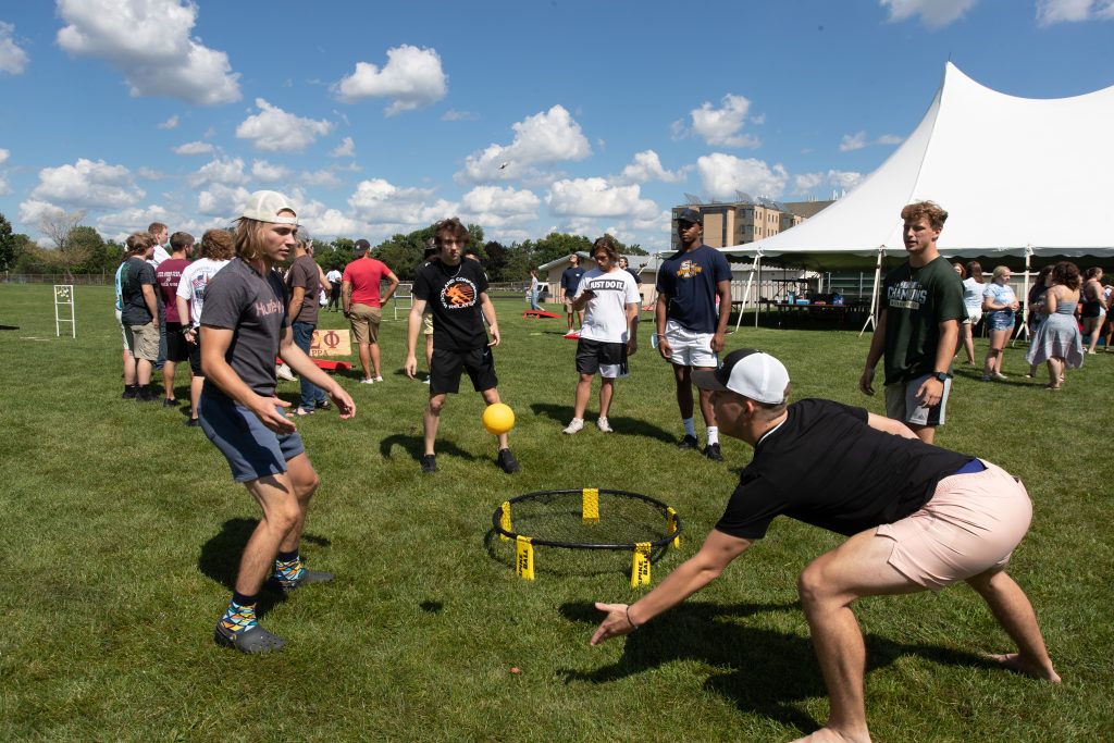Fitness and recreation image showing group of students playing spike ball on campus.