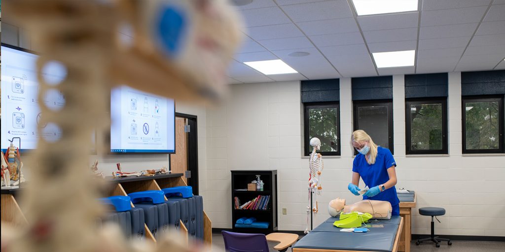 Nursing student learning on a CPR manikin.