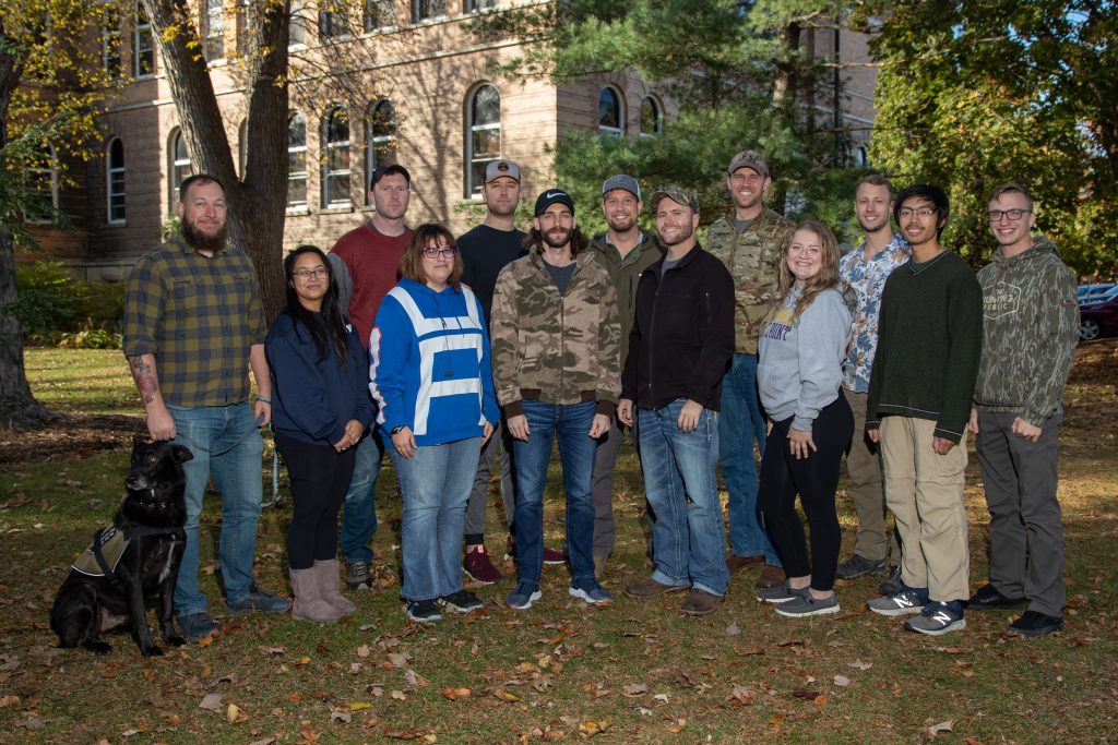 Veterans Club students in a group photo with service dog