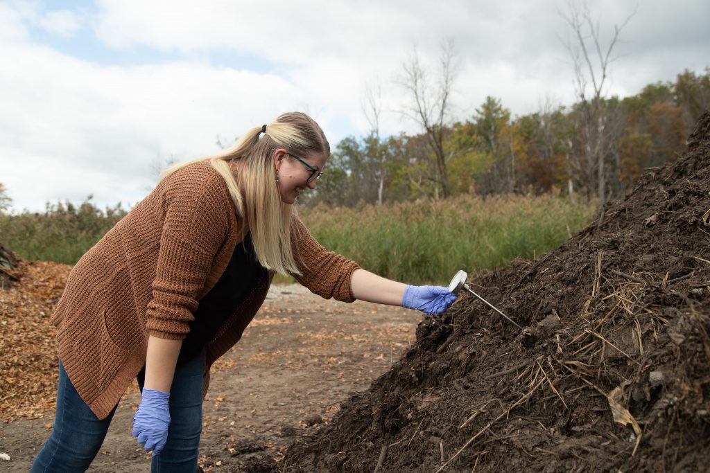 A student working with composted dirt made from the waste education center.