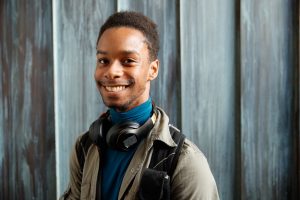 Student smiling with headphones in the Noel Fine Arts Center.