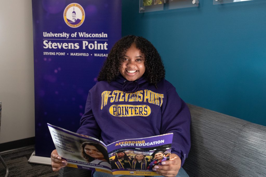 Student reading a financial aid and scholarships brochure.