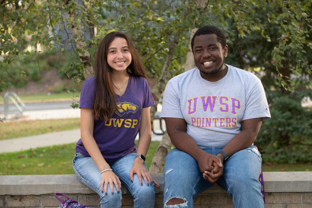 Students sitting outside with UW-Stevens Point shirts on.