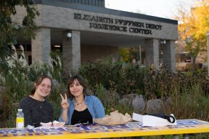 Two students eating outside of the DeBot Dining Center at a Pointer picnic table.