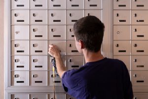 A male student checking his hall mailbox.