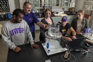 Students in the paper science and engineering lab with professor teaching them.