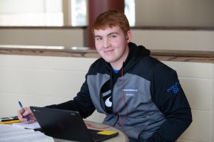 Student at laptop smiling at camera