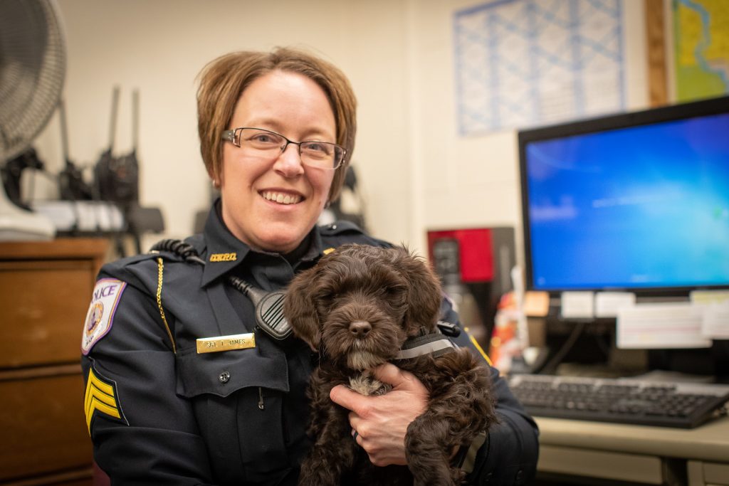 Sergent Trina James holding Tucker, the campus therapy dog.