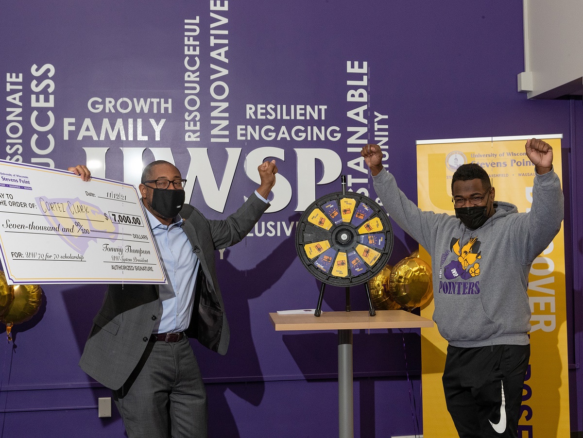Chancellor Tom Gibson and student Cortez Clark cheer with "check" for $7,000 UW scholarship.heer