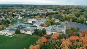 A drone photo of the Marshfield campus featuring beautiful fall trees.