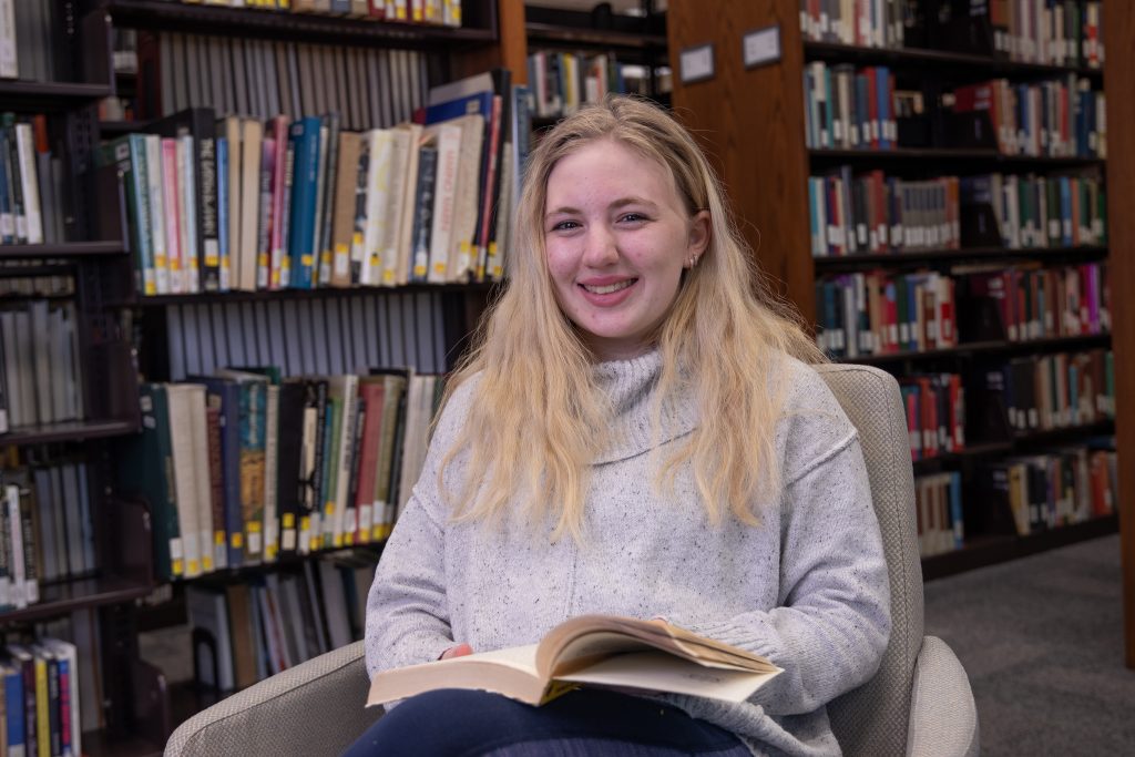 Student smiling and studying in the Wausau library.