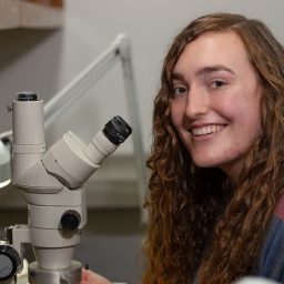 Isabel Dunn working with a microscope in the lab.