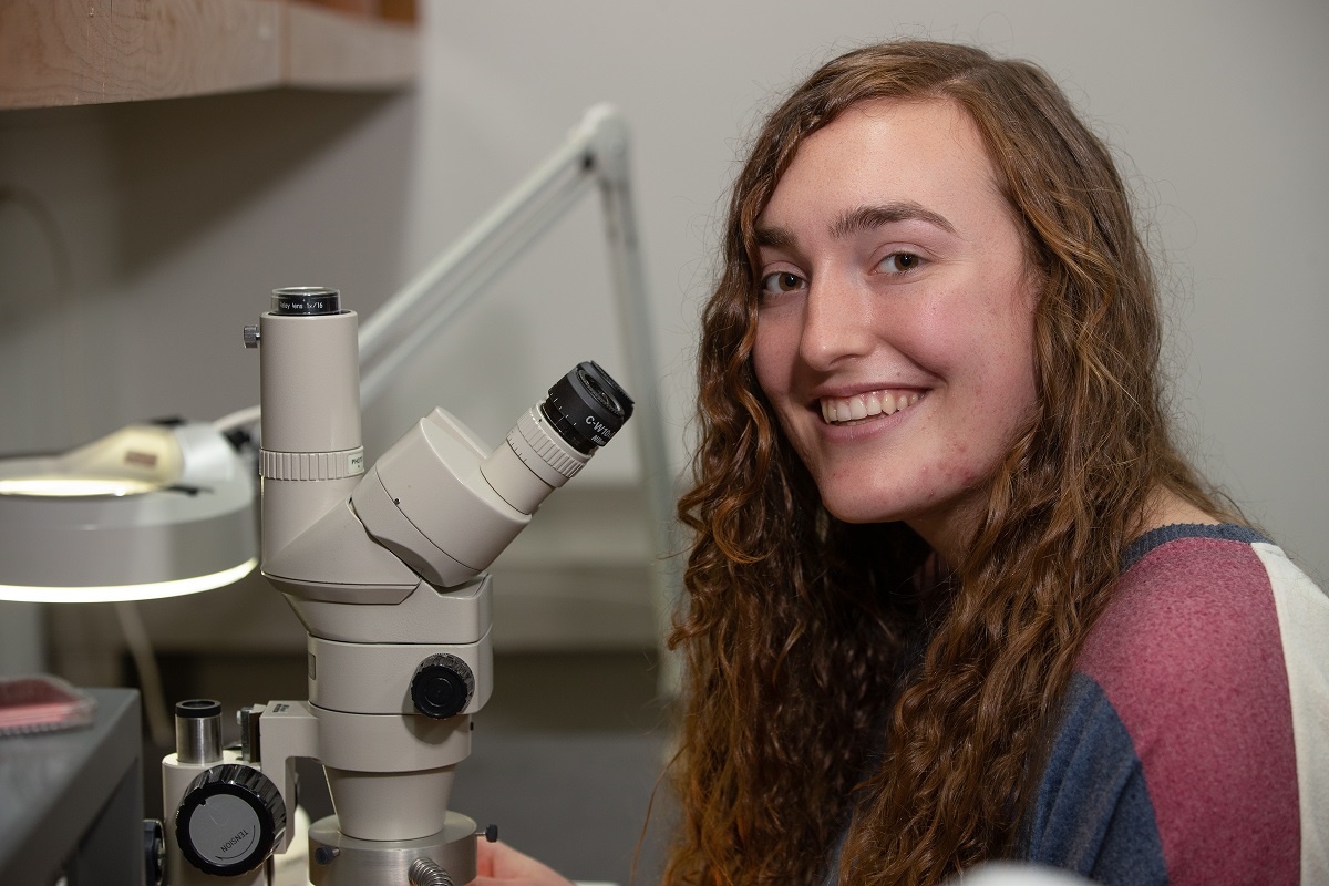 Isabel Dunn working with a microscope in the lab.
