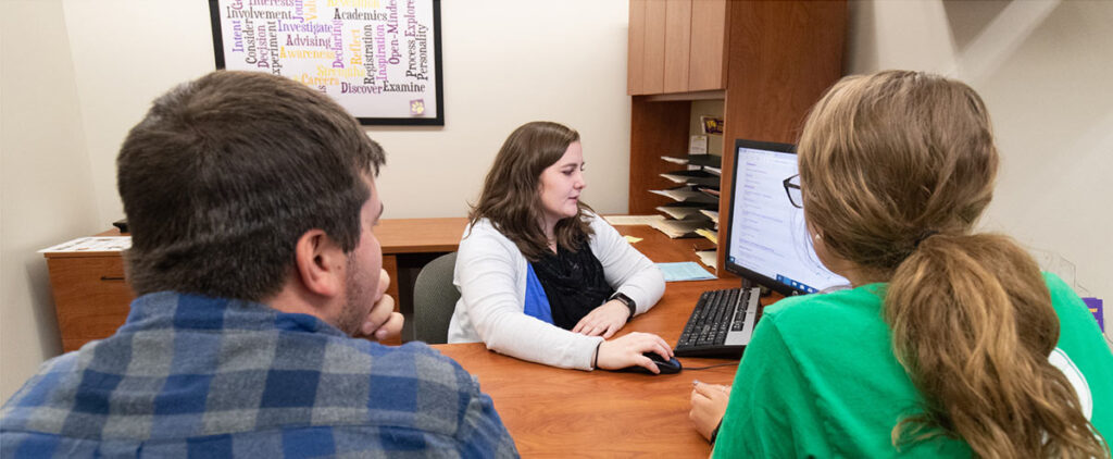 Two students and an adviser in the Academic and Career Advising Office.r