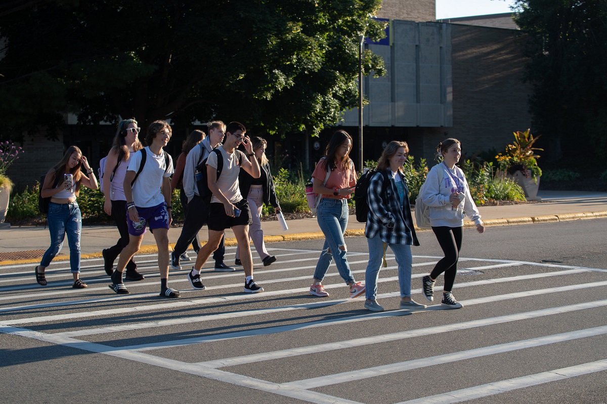 group of students walking in crosswalk on campus