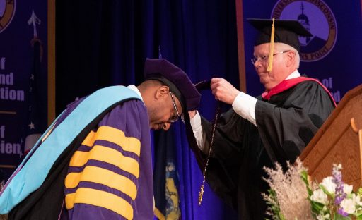 UW System President Jay Rothman places the chancellor's medallion on Chancellor Thomas Gibson