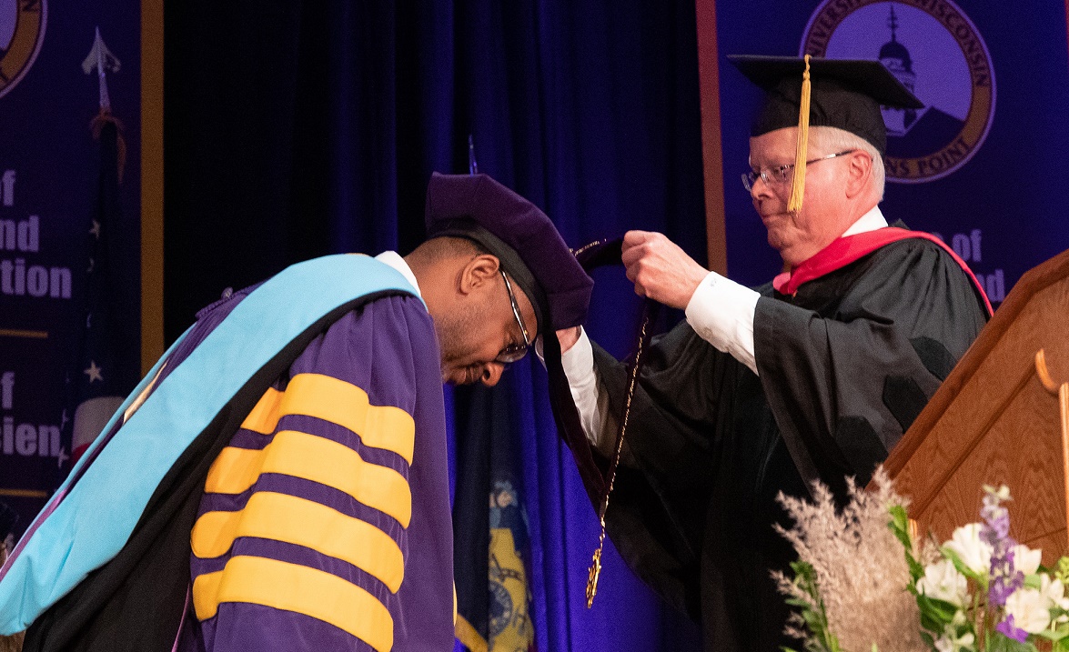 UW System President Jay Rothman places the chancellor's medallion on Chancellor Thomas Gibson