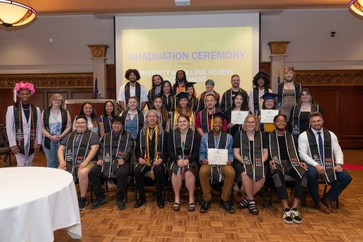 A group of graduates wearing stoles and cords from the DCA