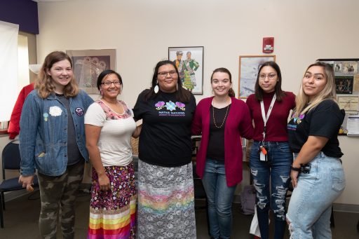 A group of students posing for a photo with their arms wrapped around each other.