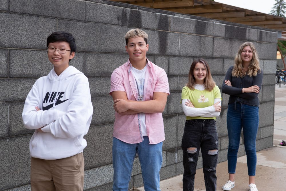 Four Upward Bound students standing with their arms crossed in front of the Dreyfus University Center.