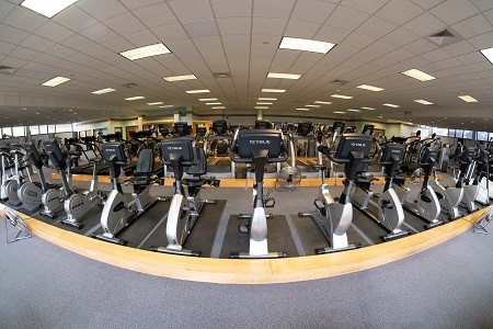 Facing all cardio machines starting with a row of stationary bikes