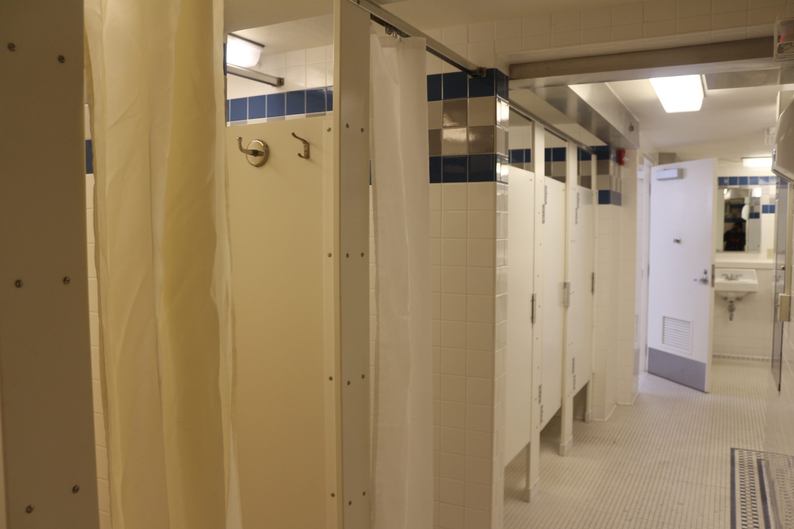 Shared floor bathroom showing shower stall and toilet stalls