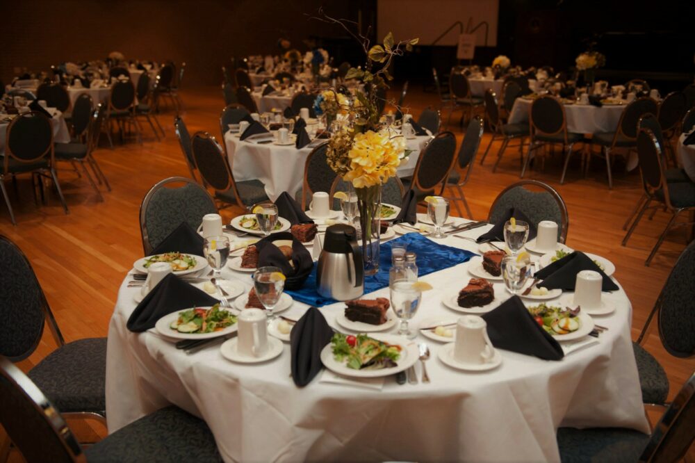 Tablescape from conference with blue and white linens and yellow flowers