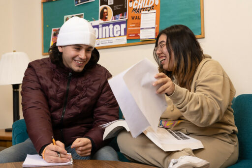 Two students studying and laughing together in the Multicultural Resource Center.