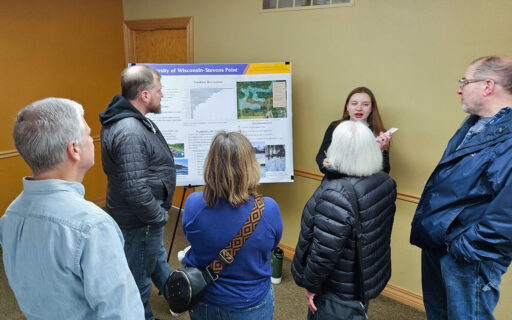 UWSP student speaking with four community members during a public input session for a capstone planning project.