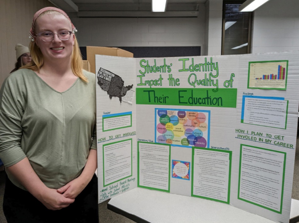 Lindsey Meyer, an English education major, displays her final project for WSG 105, in which students create posters on a topic that is important to them using what they’ve learned throughout the semester.