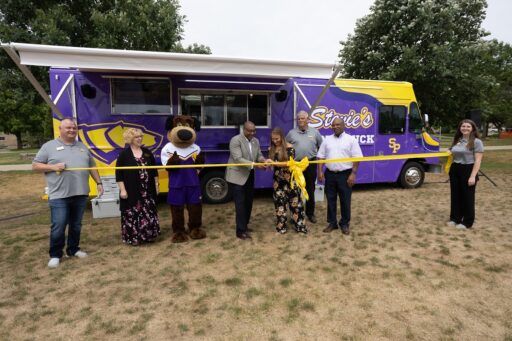 UW-Stevens Point Chancellor Thomas Gibson and alum Olivia Molle (center), along with Stevie Pointer and Student Affairs and University Dining staff, recently cut a ceremonial ribbon to officially open Stevie’s food truck, which will debut off campus on July 21.